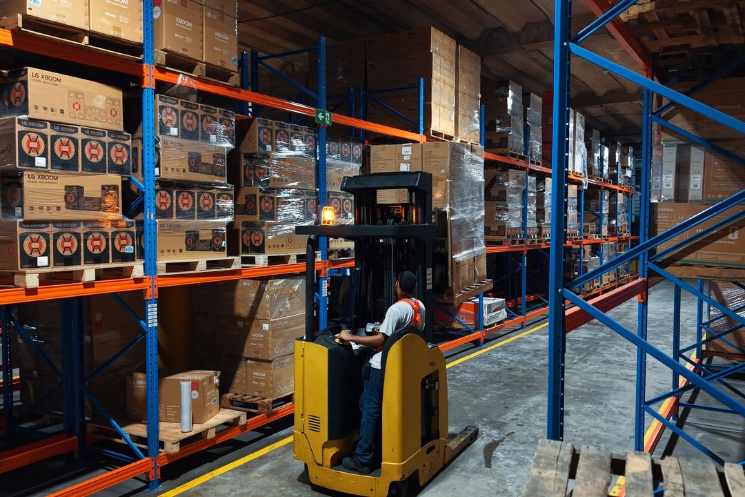 Racks de almacenaje con inventario y montacargas retráctil en operación